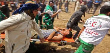 رجال الإسعاف يحاولون إنقاذ أحد المصابين فى مسيرة «العودة الكبرى»