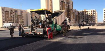 عمال الأسفلت خلال العمل بمدينة العبور