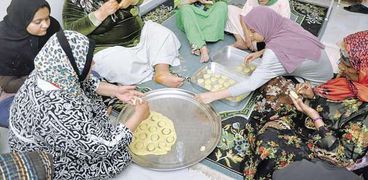 نزيلات دار الإيواء أثناء إعداد «كعك العيد» لتوزيعه على المشردات