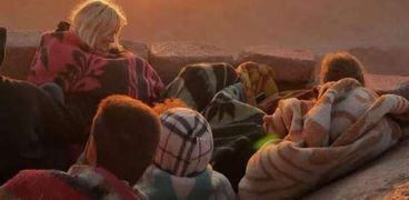 سياح يشاهدون شروق الشمس فوق جبل موسي بسانت كاترين