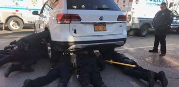 سبعة رجال شرطة يشاركون في عملية إنقاذ قطة عالقة تحت سيارة