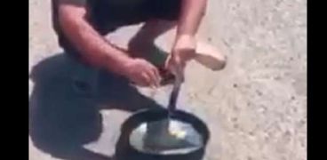 رجل يقلي البيض على حرارة الشمس المرتفعة