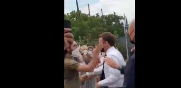 الرئيس الفرنسي إيمانويل ماكرون خلال تعرضه لمحاولة صفع من جانب أحد الشبان