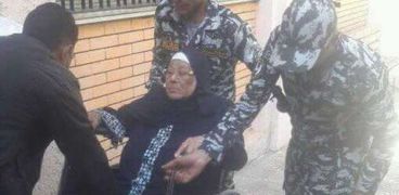 قوات التأمين تنقل مسنة لمساعدتها في الادلاء بصوتها وسط الإسكندرية