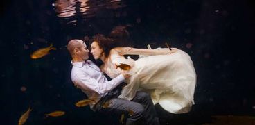 عروسان فى جلسة تصوير تحت الماء