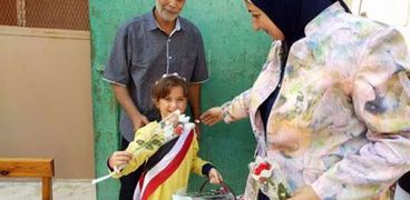 طالبة توزع الورد احتفالًا بنصر أكتوبر بمدرسة بجمرك التعليمية بالإسكندرية