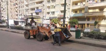 عمال نظافة يؤدون عملهم بأحد شوارع الجيزة