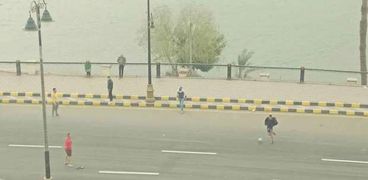 شباب بني سويف يمارسون لعبة الكرة وسط الطقس السيء