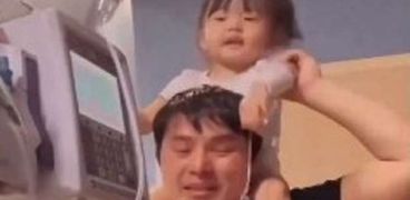 أب يلاعب طفلته في أثناء تلقيها جرعة الكيماوي الأولى