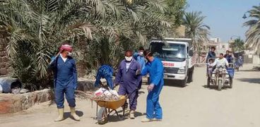 عمال النظافة خلال رفع المخلفات من شوارع سيوة