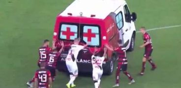 تعطل عربة إسعاف في ملعب كرة قدم واللاعبون يدفعونها