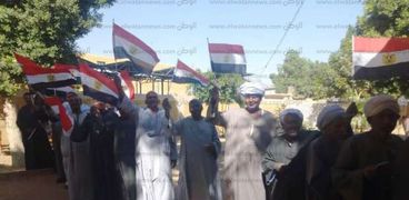 كبار السن والأطفال بأسوان يرفعون أعلام مصر في المقرات الانتخابية