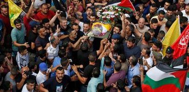 فلسطينيون يحملون جثمان شاب قتل أثناء غارة إسرائيلية على بلدة بيت ريما