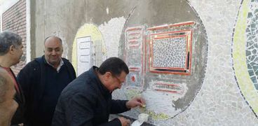 مدير وسط التعليمية بالإسكندرية يشارك في تنفيذ جدارية بالمدرسة