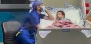 «عمر» ممرض يرعى طفلة بمستشفى 57357