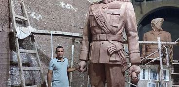 «مينا» مع تمثال الرئيس السادات