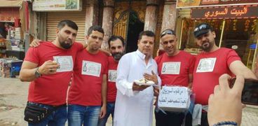 سوريون يوزعون حلوى على المارة فى الإسكندرية