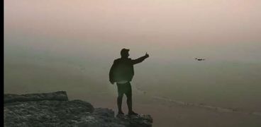 سعودي يقف على حافة جبل فهرين