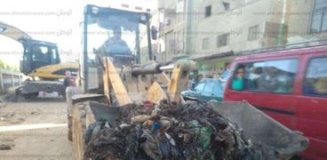 رفع أكوام القمامة المتراكمة على ترعة السنط بمدخل قرية كوم أبو شيل بأبنوب