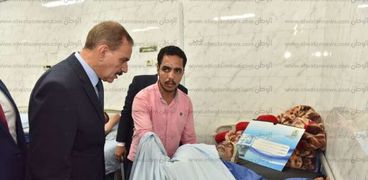 محافظ أسيوط يزور صاحب المنزل المنهار ونجله بالمستشفى الجامعى