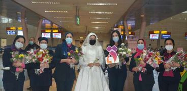 المجلس القومي للمرأة يوزع الورود على السيدات بمطار القاهرة