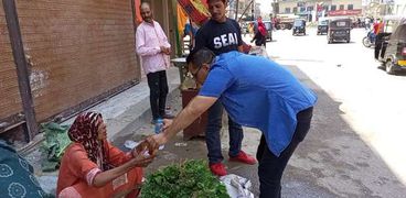 موظفو مدينة بلقاس أثناء توزيع «المياه والعصير» على البائعين
