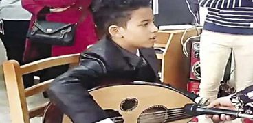 الطفل «حسام» يعزف على العود