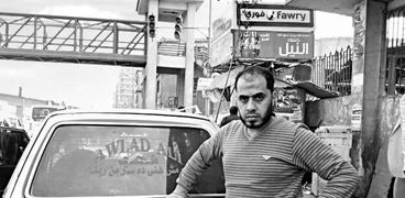 «محمد» أمام سيارة تشييع الموتى