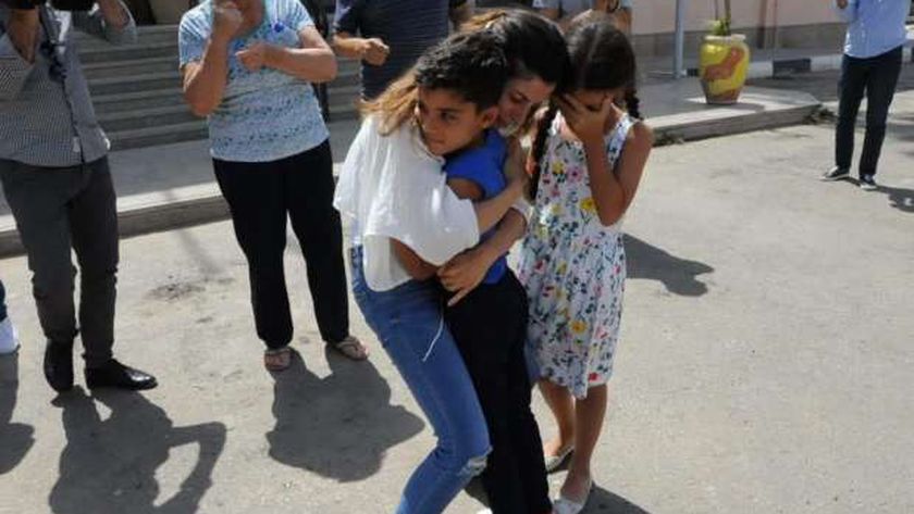 الام أثناء احتضان طفلها عقب تحريره من قبل قوات الأمن